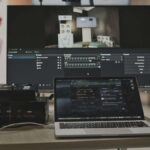 Multimedia setup featuring a laptop and a large monitor in a tech-savvy workspace.