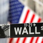 Papan layar elektronik yang menampilkan pergerakan indeks bursa saham di Wall Street, New York.