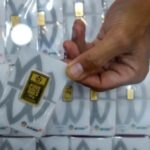 Kepingan emas batangan Antam dengan logo perusahaan