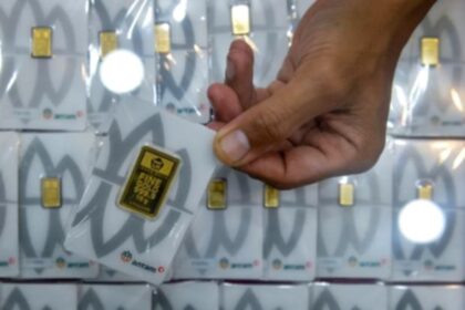 Kepingan emas batangan Antam dengan logo perusahaan