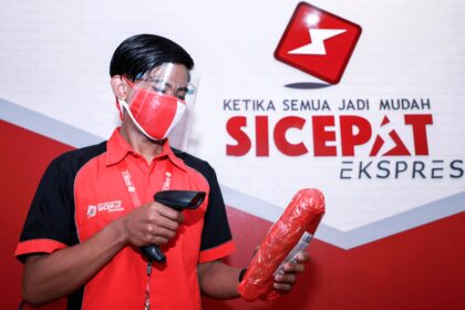 Kurir SiCepat sedang memproses paket pengiriman di gudang logistik untuk persiapan lonjakan permintaan semester II 2026.