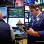 Papan layar elektronik menampilkan pergerakan indeks bursa saham Wall Street di New York