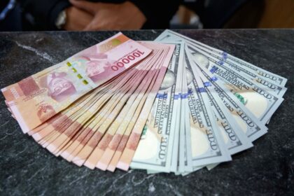 Grafik pergerakan nilai tukar rupiah terhadap dolar AS di layar monitor perdagangan.