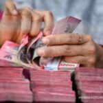 Ilustrasi mata uang rupiah Indonesia dengan latar belakang simbol dolar Amerika Serikat