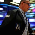 Papan layar elektronik yang menampilkan pergerakan indeks saham di bursa Wall Street, New York.