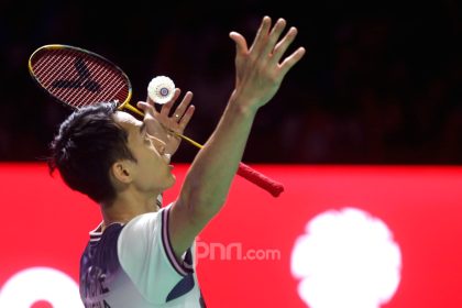 Jonatan Christie merayakan kemenangan di lapangan bulu tangkis setelah resmi menempati peringkat satu dunia BWF.