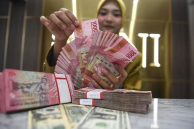 Papan informasi nilai tukar mata uang yang menunjukkan pelemahan rupiah terhadap dolar AS