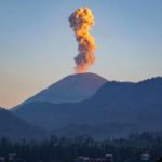Aktivitas vulkanik berupa kolom abu yang menyembur dari kawah gunung api saat erupsi.