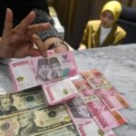 Grafik pergerakan nilai tukar mata uang rupiah terhadap dolar Amerika Serikat di layar monitor perdagangan.